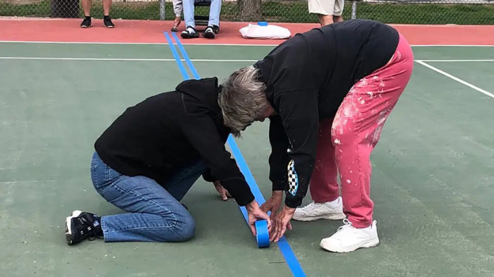 Applying Painter's Tape For Painting Lines On A Pickleball Court With Pickleball Court Paint